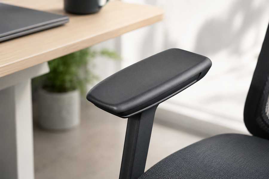 Person sitting in an ergonomic chair with properly adjusted armrests supporting their forearms at desk