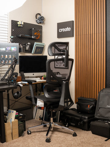 Dark mesh OdinLake office chair in a workspace with black equipment and warm wood wall panels