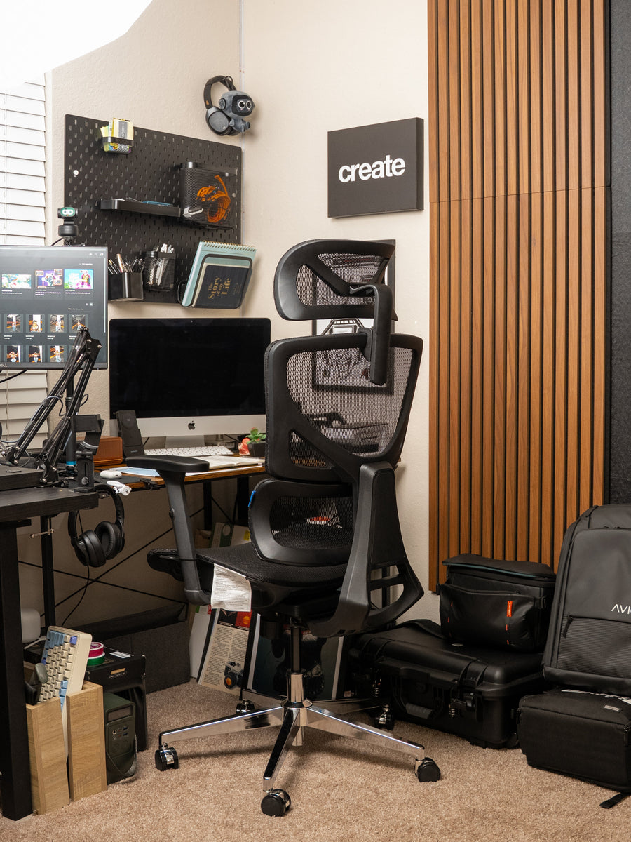 Dark mesh OdinLake office chair in a workspace with black equipment and warm wood wall panels
